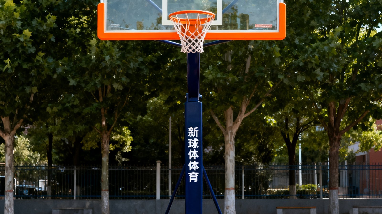 新球体育可调节高度标准校园篮球架产品展示图，钢化玻璃篮板透明度极高，橙色边框与深蓝色立柱形成鲜明对比，底部配备万向轮方便移动